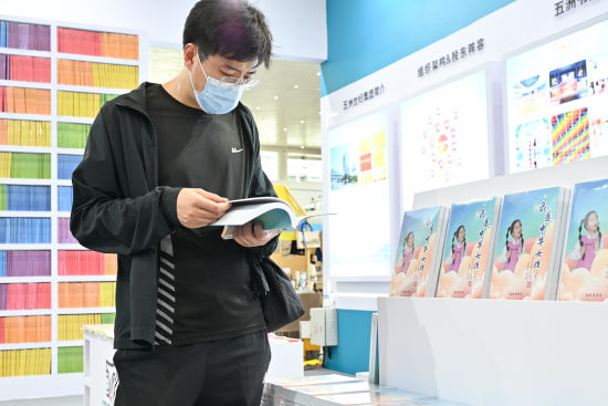图为市民翻阅《我是中华女孩》 一书。安梓诚摄 图为市民翻阅《我是中华女孩》 一书。安梓诚摄