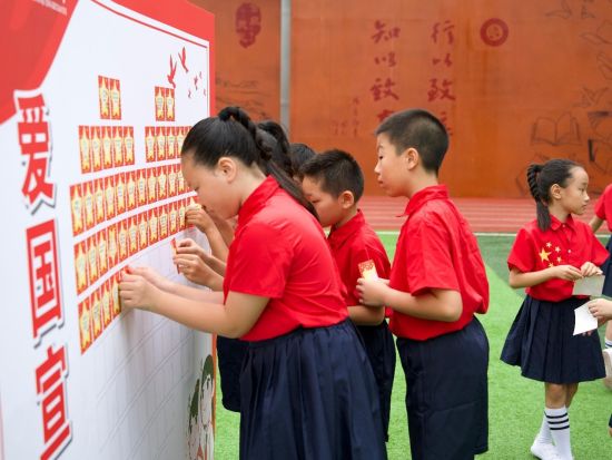 图为学生张贴爱国宣言。合川区行知小学供图 图为学生张贴爱国宣言。合川区行知小学供图