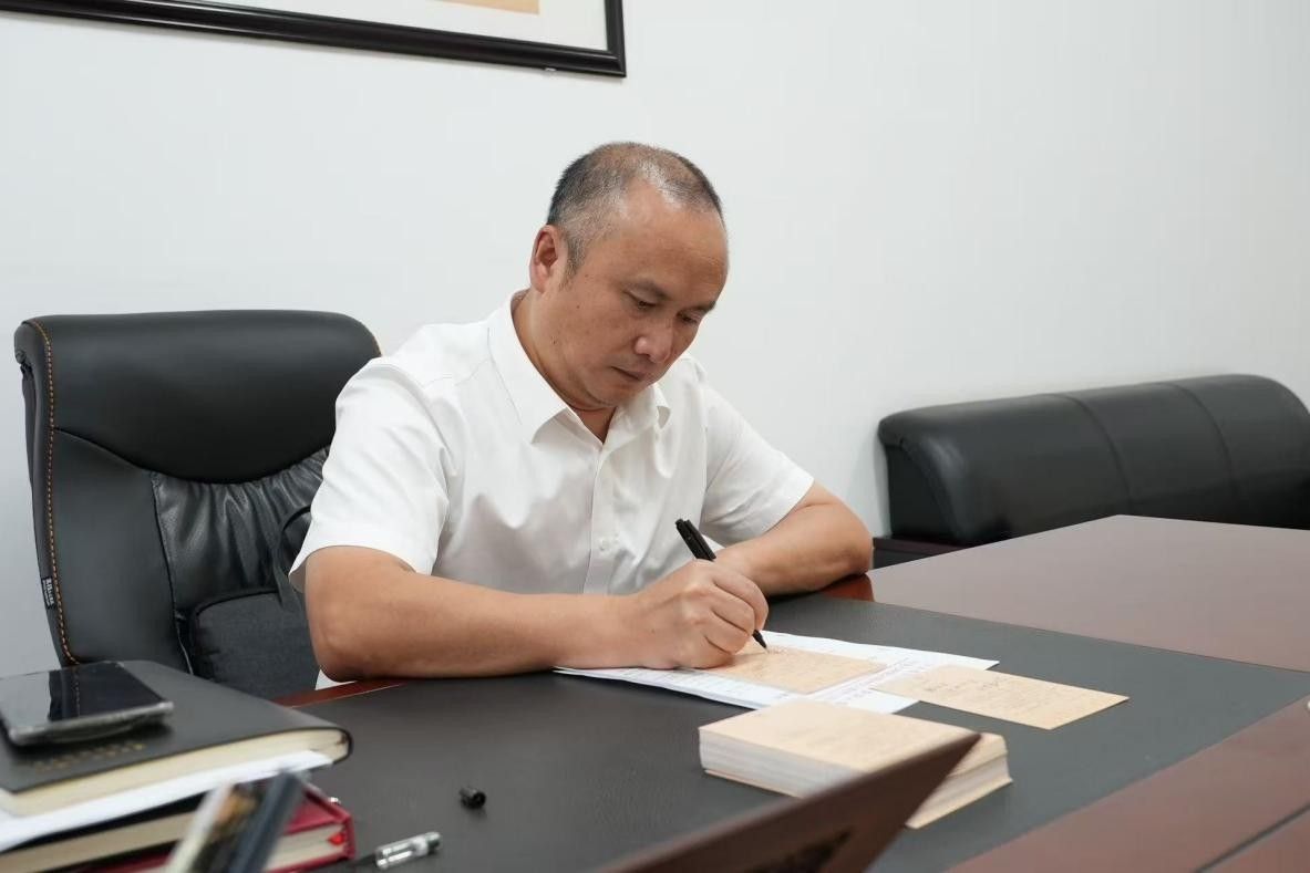 图为潼南中学党委书记侯君辅为全体教师写贺卡。潼南中学 供图 图为潼南中学党委书记侯君辅为全体教师写贺卡。潼南中学 供图