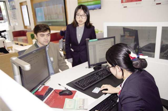 图为中国银行重庆市分行为持卡外籍人士开通社保卡的金融功能。 中国银行重庆市分行供图 图为中国银行重庆市分行为持卡外籍人士开通社保卡的金融功能。 中国银行重庆市分行供图