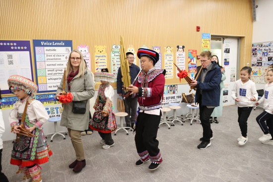 图为代表团成员在重庆两江新区博雅小学校与重庆万盛红苗非遗传承人、学生共跳舂米舞。 重庆两江新区博雅小学校供图 图为代表团成员在重庆两江新区博雅小学校与重庆万盛红苗非遗传承人、学生共跳舂米舞。 重庆两江新区博雅小学校供图