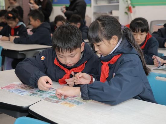 图为小朋友根据真币实物学习人民币纸币真假辨别要点。兴业银行重庆分行 供图 图为小朋友根据真币实物学习人民币纸币真假辨别要点。兴业银行重庆分行 供图