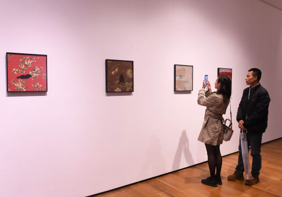 图为精美艺术作品吸引参观者驻足欣赏拍照。周毅 摄 图为精美艺术作品吸引参观者驻足欣赏拍照。周毅 摄