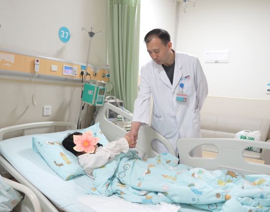 安永医生评估患儿右手力量。重医附属儿童医院供图 安永医生评估患儿右手力量。重医附属儿童医院供图