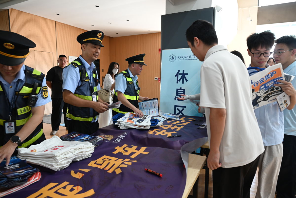 图为执法人员在重庆城市科技学院进行拒乘黑车相关的宣传。张旭 摄 图为执法人员在重庆城市科技学院进行拒乘黑车相关的宣传。张旭 摄