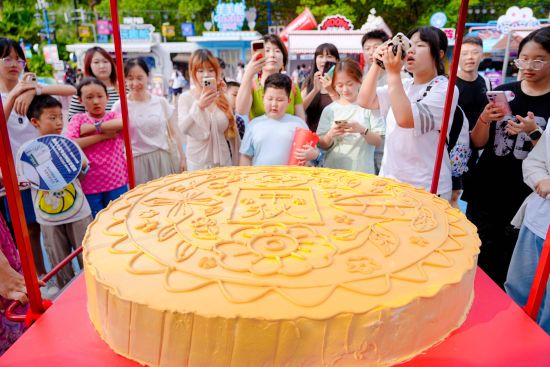图为巨型月饼吸引游客驻足围观拍照。重庆欢乐谷供图 图为巨型月饼吸引游客驻足围观拍照。重庆欢乐谷供图