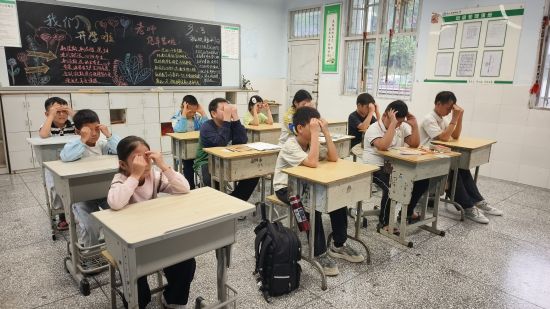图为服务队队员在塘坳小学带领学生做眼保健操。廖霜 摄 图为服务队队员在塘坳小学带领学生做眼保健操。廖霜 摄